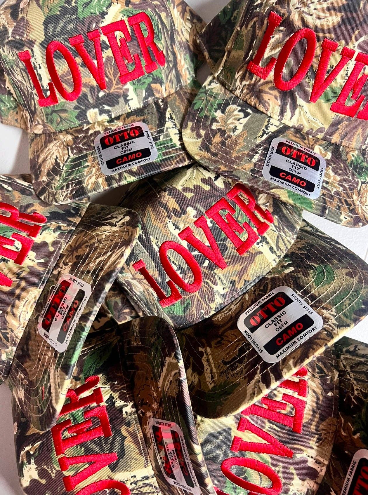 Vintage camouflage trucker hat with red embroidered Lover lettering and streetwear styling