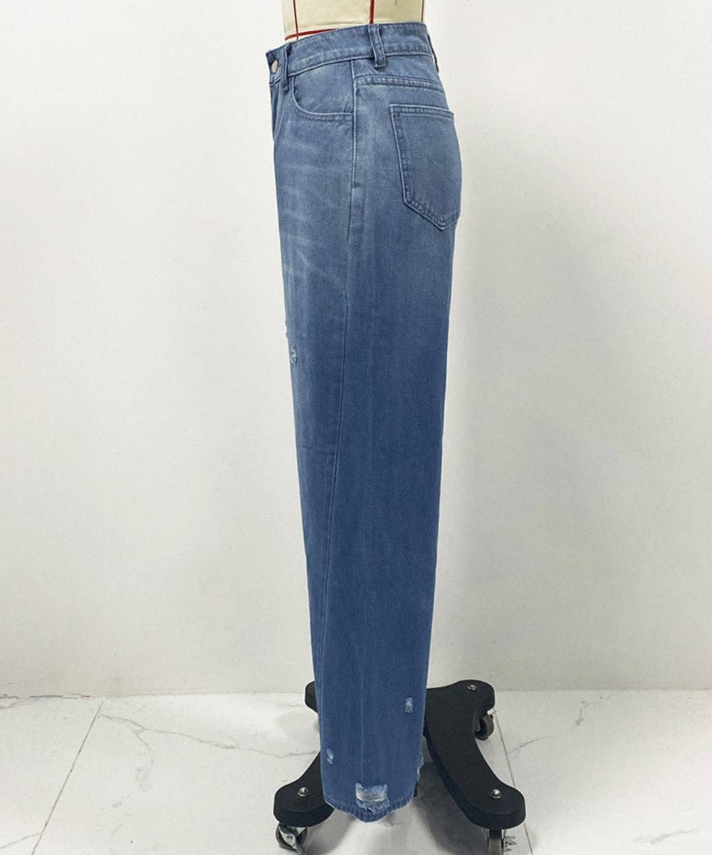 A pair of medium-wash blue denim jeans displayed on a dress form mannequin, standing on a black rolling stand against a plain white wall.