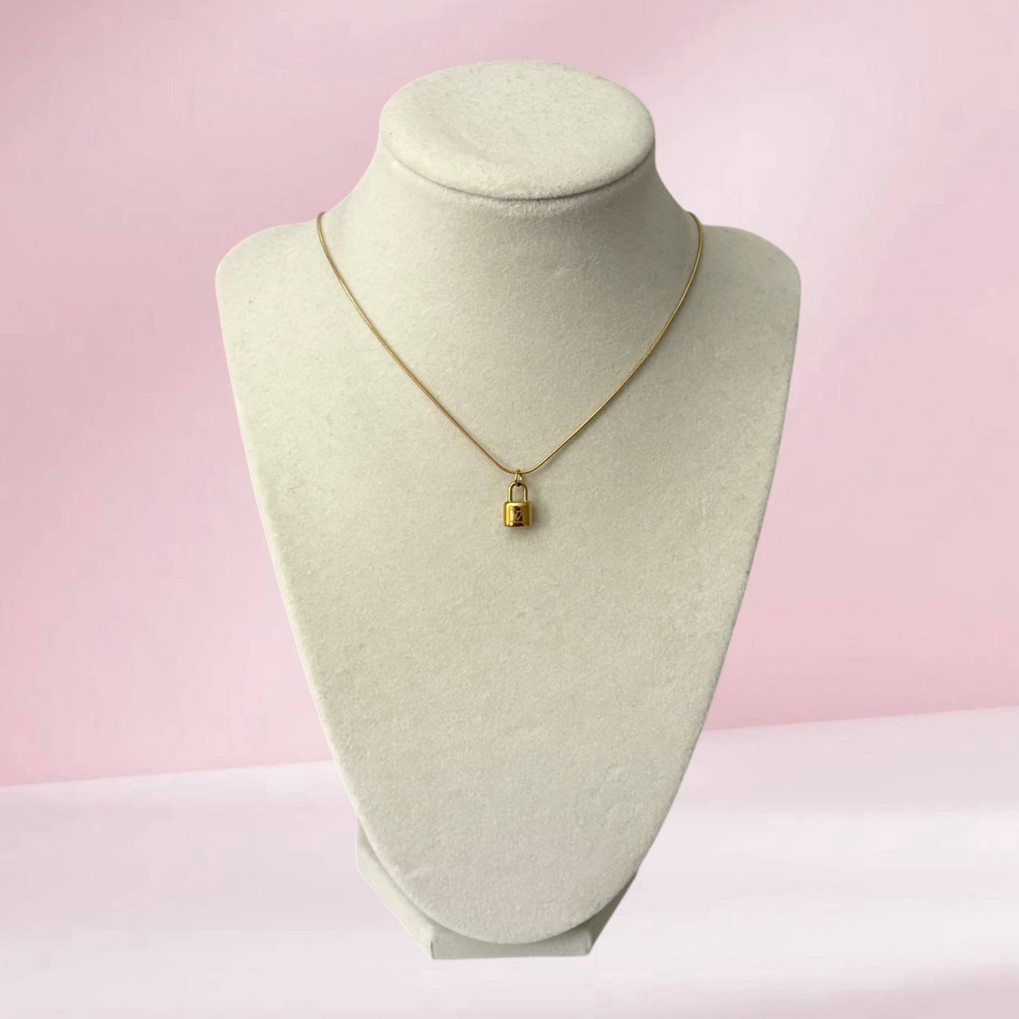 Repurposed gold lock pendant necklace on snake chain with minimalist luxury inspired styling