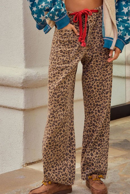 Leopard print wide leg cargo pants with relaxed streetwear styling and red drawstring detail
