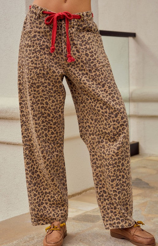 Leopard print wide leg cargo pants with relaxed streetwear styling and red drawstring detail