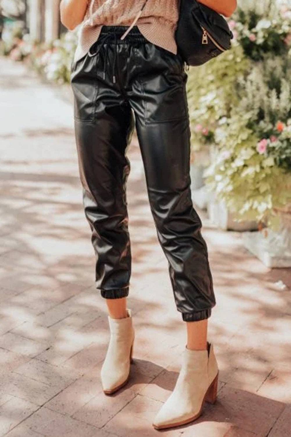 Black faux leather jogger pants with relaxed edgy streetwear styling