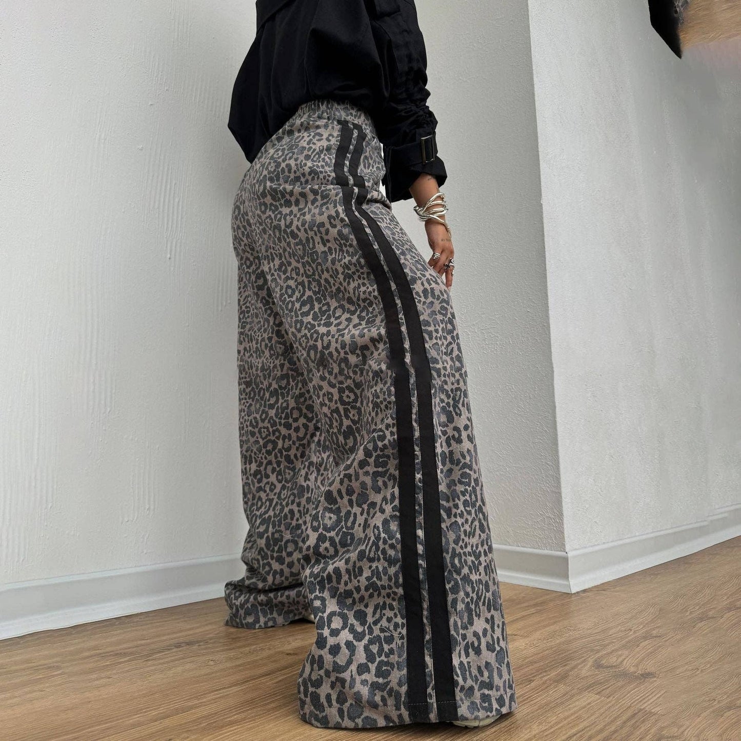 Leopard print wide leg track pants with side stripe detail and relaxed streetwear styling