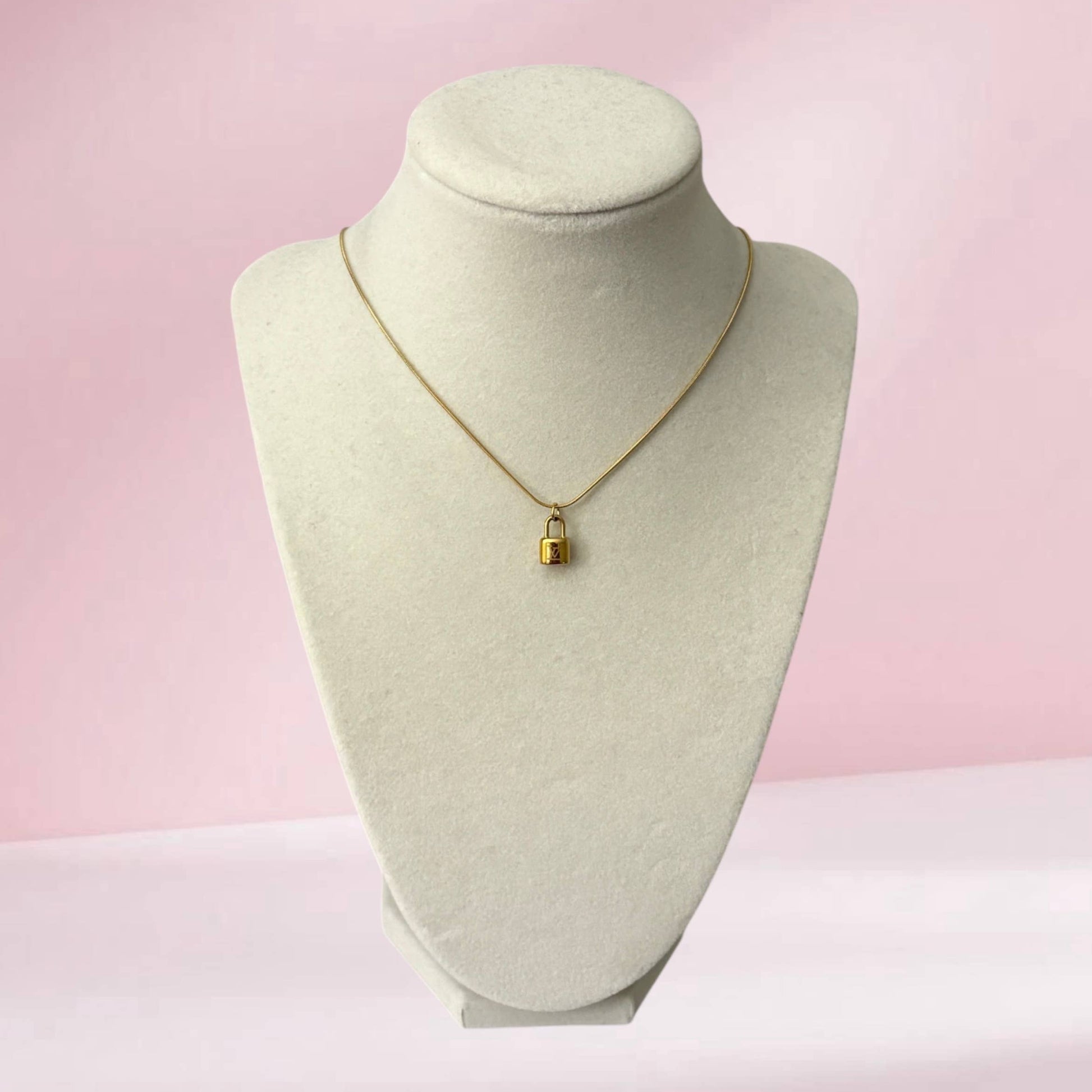 Repurposed gold lock pendant necklace on snake chain with minimalist luxury inspired styling