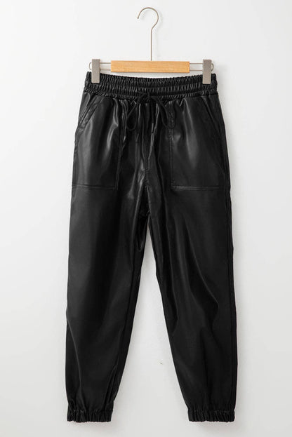 Black leather jogger pants on a hanger against a white background