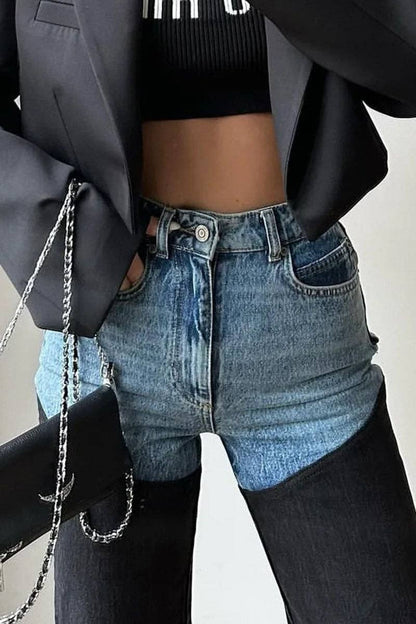 Person wearing a black blazer, black crop top, and blue denim shorts with a neutral background