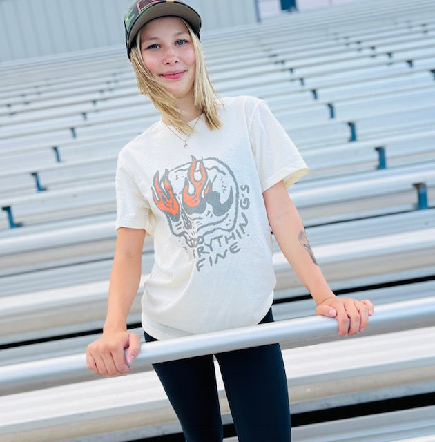 Person wearing a white t-shirt with a graphic design in an outdoor setting