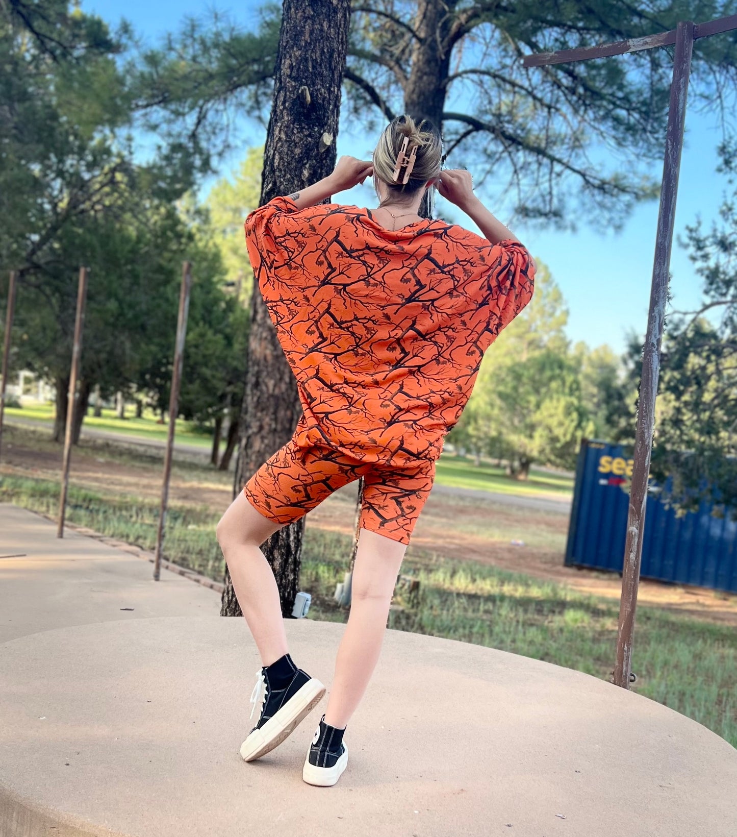 Person wearing an orange patterned dress in a park setting