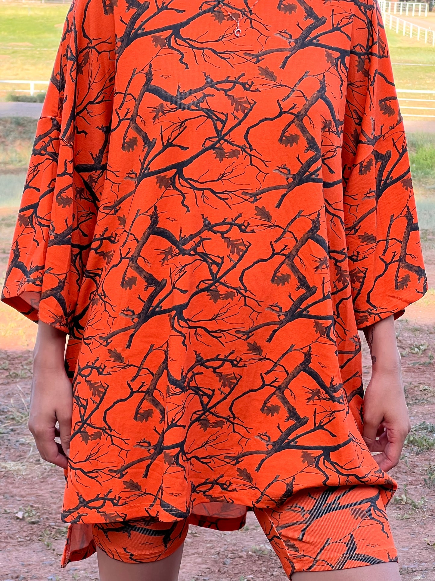 Orange fabric with black tree branch pattern held by a person