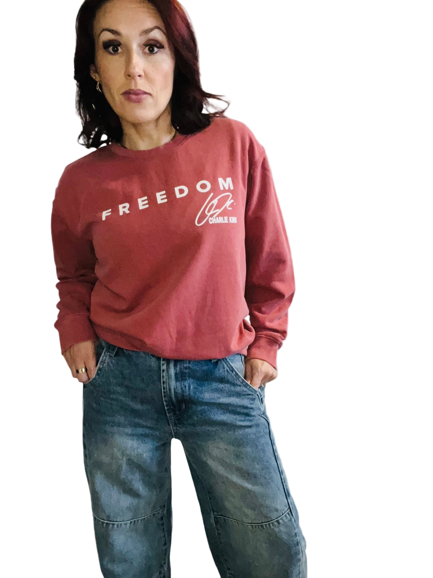 woman in crimson sweater and jeans in front off white background