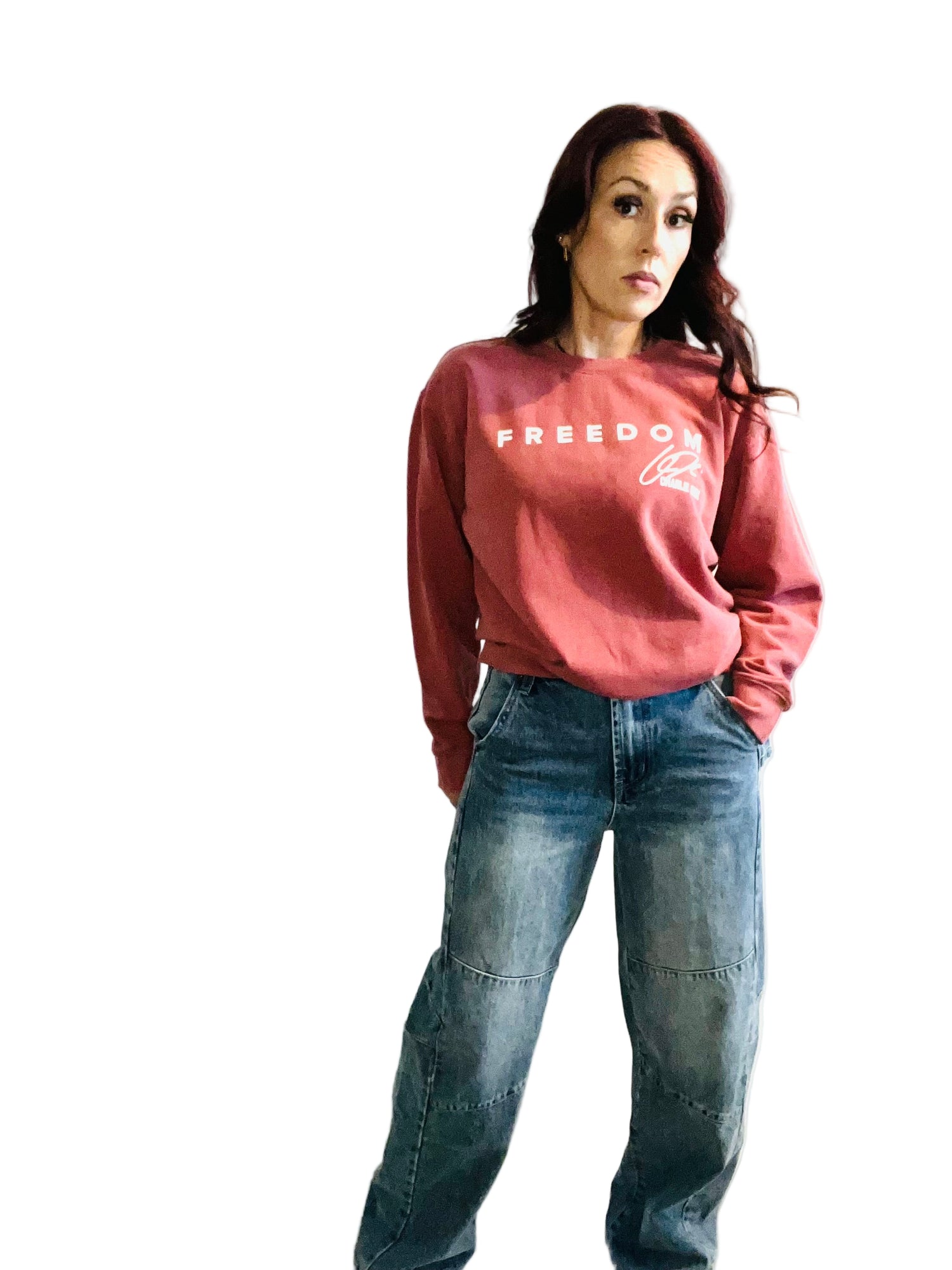 woman in crimson sweater and jeans in front off white background