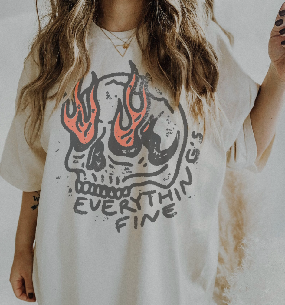 Person wearing a white t-shirt with a skull design and 'Everything's Fine' text.