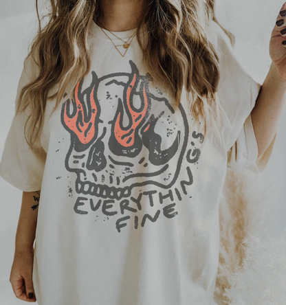Person wearing a white t-shirt with a skull design and 'Everything's Fine' text.