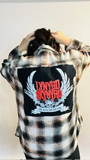 Person wearing a plaid shirt with a graphic design on a plain background