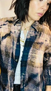 Person wearing a plaid shirt with a neutral background