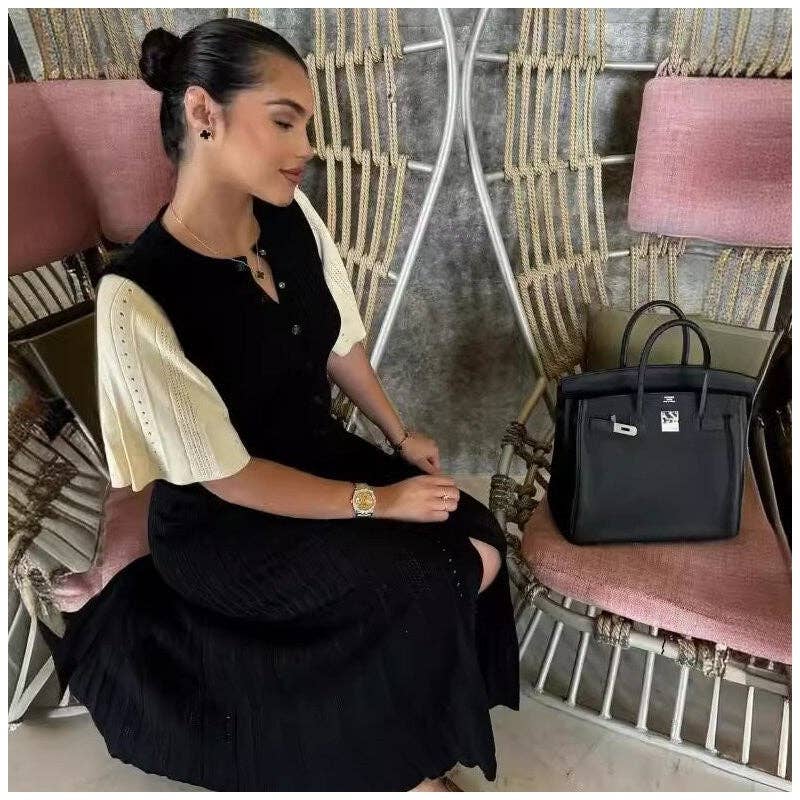 Woman wearing a black and cream modest knit maxi dress with minimalist elegant styling