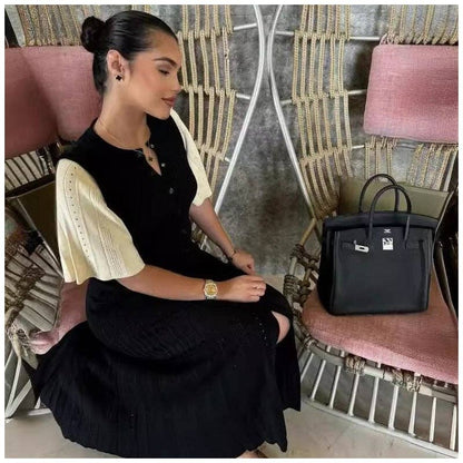 Woman wearing a black and cream modest knit maxi dress with minimalist elegant styling