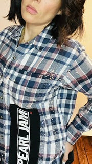 Person wearing a plaid shirt with a visible brand logo.