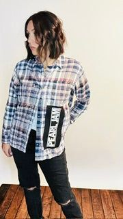 Person wearing a plaid shirt with a visible brand logo on a white background