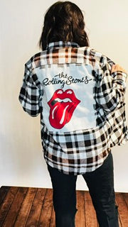 Person wearing a plaid shirt with Rolling Stones logo