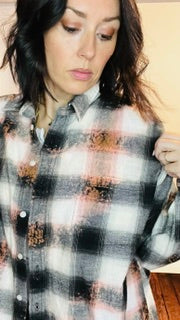 Person wearing a plaid shirt with a blurred background