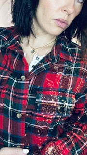 Person wearing a red and black plaid shirt with a blurred background