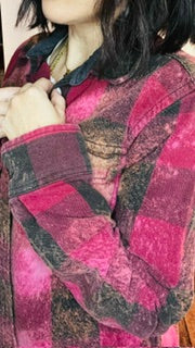 Person wearing a plaid shirt with a focus on the fabric pattern.