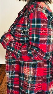 Red and black plaid shirt worn by a person, with a neutral background