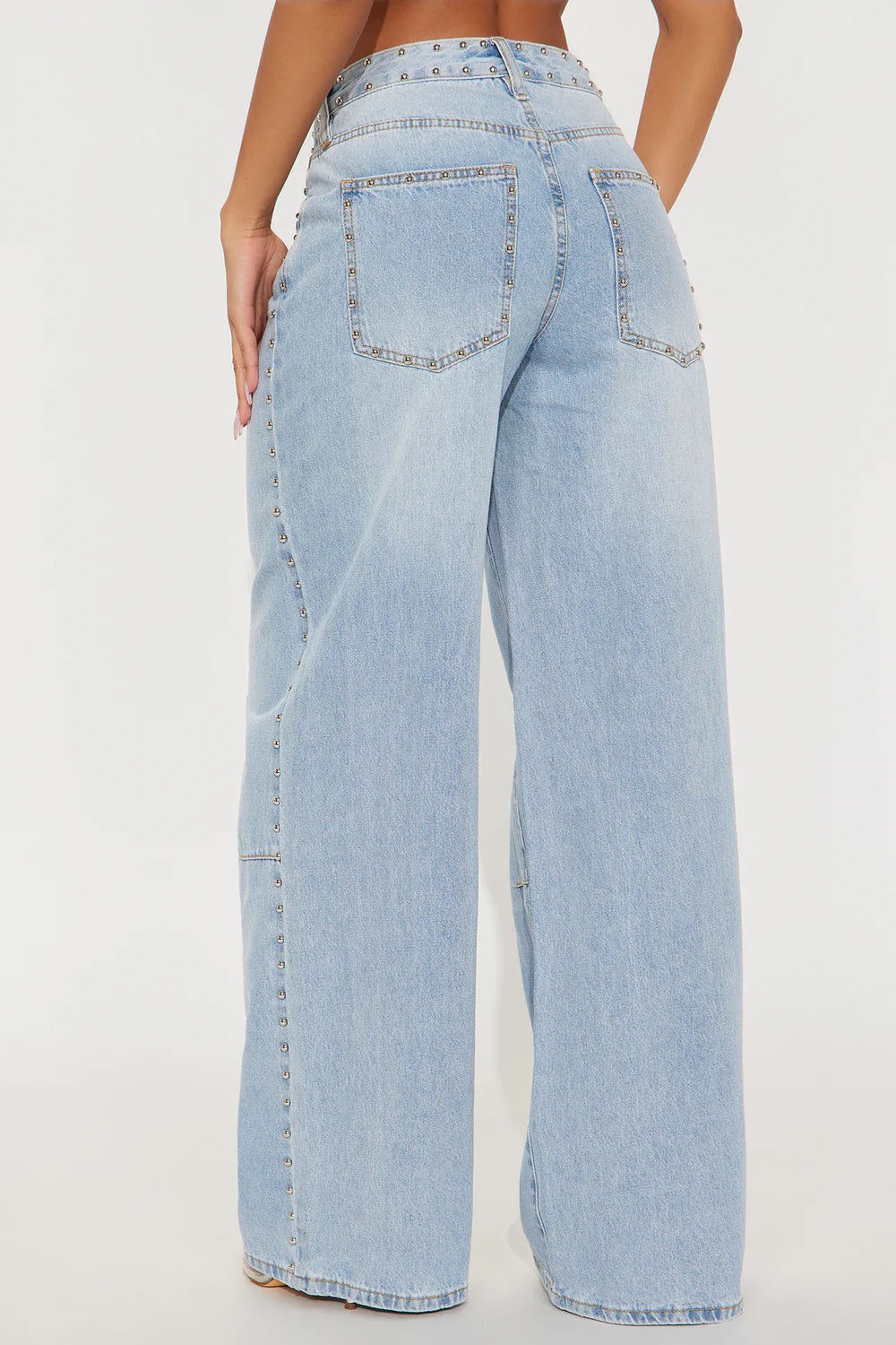 Light wash wide leg jeans with silver stud details and edgy streetwear styling